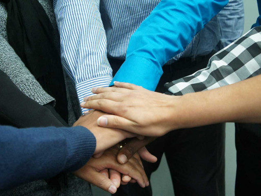 Group of hands placed on top of one another.