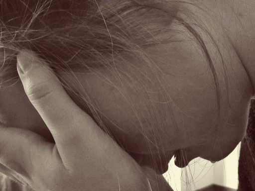 Young girl with her head in her hands.