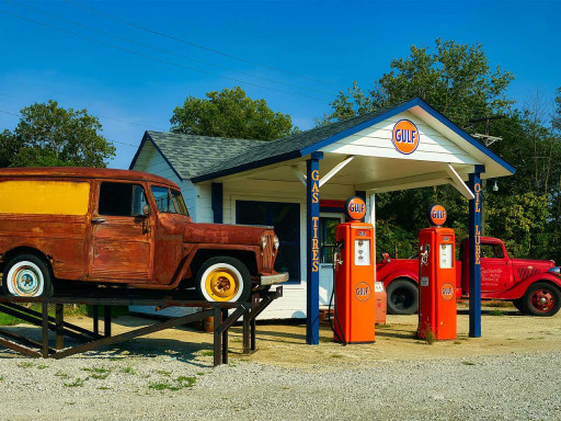 Petrol station with two old card out front.